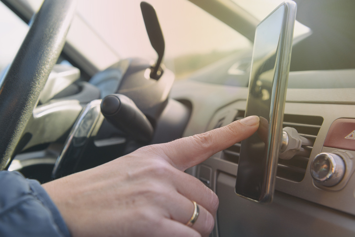 Woman using smart phone as navigation while driving the car. Risky driving behaviors concept