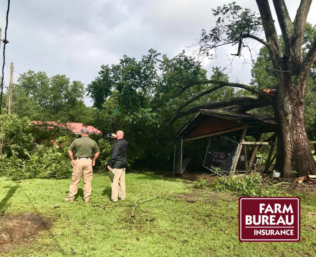 Two men surveying damaged property.