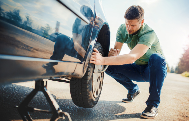 Man changing wheel after a car breakdown. Transportation, traveling concept